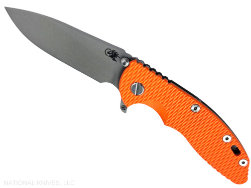 Rick Hinderer Knives XM-18 Skinny Slicer with thumb stud and flipper tab - shown open presentation side.  Working Finish Magnacut stainless steel, hollow ground, plain edge blade.  Orange G-10 handle with Battle Bronze lock side.  Model KXM35SKSL.