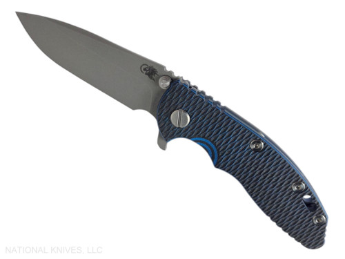 Rick Hinderer Knives XM-18 3.25" Spear Point folding knife with thumb stud and flipper tab - shown open presentation side.  Working Finish S45VN stainless steel plain edge blade.  Blue - black G-10 handle with Battle Blue lock side.  Model KXM325SPE.