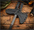 RMJ Tactical Kestrel Feather Tomahawk - shown close up of head in sheath obverse.  Tungsten Cerakote 80CrV2 steel head.  Black G-10 handle scales.  Model T-KF-TU-BL.