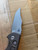 USED Rick Hinderer Knives XM-18 Automatic Bowie knife with push button - shown open presentation side blade.  Working Finish S45VN stainless steel plain edge blade.  Battle Bronze titanium handle. 