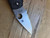 Blemished Native 5 folding knife with thumb hole - close up of presentation side blade shown.  Satin S30V stainless steel serrated edge blade.  Black FRN handle.  Model C41SBK5.