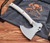 RMJ Tactical Explore More Weeserker Camp Axe - shown out of sheath obverse.  Tungsten Cerakote 52100 steel plain edge head.  Gray and orange G-10 handle.
For reference only.