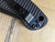Used Spyderco Military 2 Salt folding knife with thumb hole - close up of pocket clip screws shown.  Black CPM MagnaCut stainless steel plain edge blade.  Black G-10 handle.  Model C36GMCBKP2.