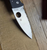 Blemished Spyderco Bodacious folding knife with thumb hole - close up of presentation side blade shown.  Satin S30V stainless steel serrated edge blade.  Black G-10 handle.  Model C263GS.