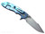 Rick Hinderer Knives XM-18 Skinny Harpoon Spanto with thumb stud and flipper tab - shown open lock side.  Stonewash MagnaCut stainless steel plain edge blade.  Black G-10 handle with stonewash blue lock side.  Model KXM35SKHS.