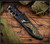 RMJ Tactical Marauder - shown in sheath obverse. Savage Stainless Cerakote 3V steel plain edge blade.  Black G-10 handle scales.  Model K-MD-3V-SS-BLK-BLK/VT.