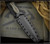 RMJ Tactical Kilroy fixed blade knife - shown in sheath obverse.  OD Green Cerakote M390 steel, double plain edge, blade.  Dirty Olive G-10 handle scales. Model K-KRY-M390-ODG-DO.