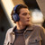Male model wearing Bowers & Wilkins Px7 S3 Indigo Blue over-ear headphones, side profile lifestyle shot, warm ambient lighting