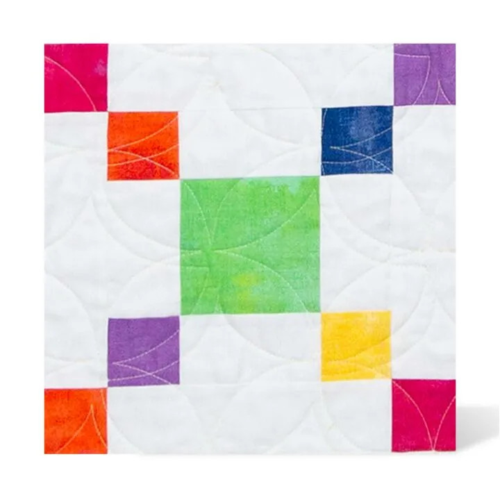 A colorful quilt block with geometric patterns on a white background.