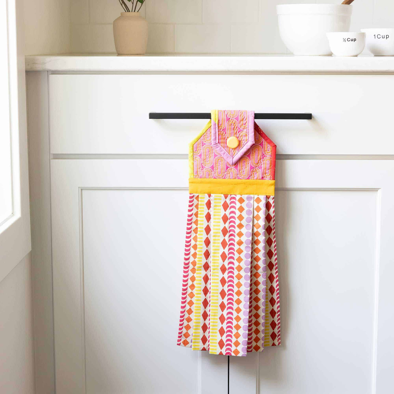 Colorful kitchen towel hangs neatly on a cabinet in a modern kitchen.