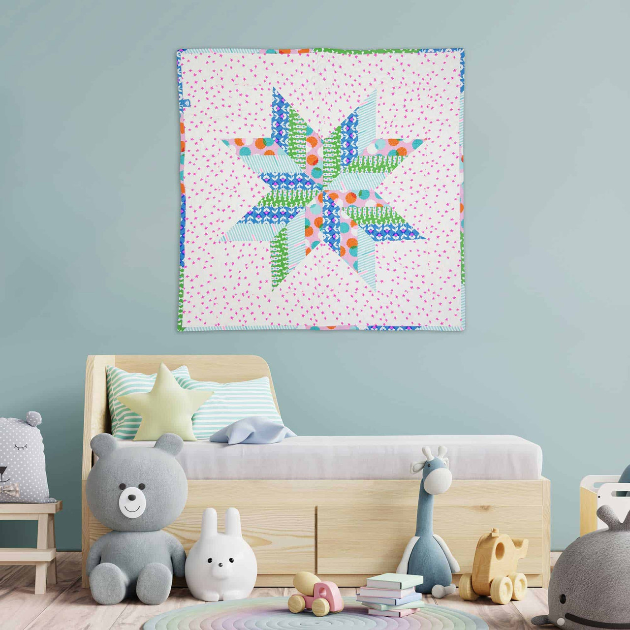 A colorful star-pattern quilt decorates a child's room with plush toys.
