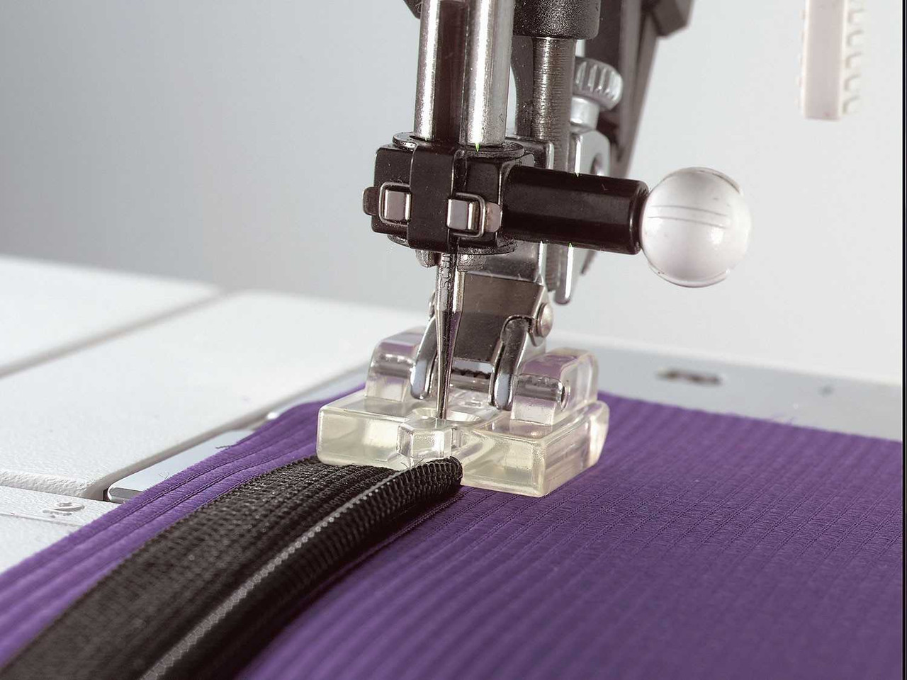 Invisible zipper presser foot for sewing machines, shown clearly on plain background