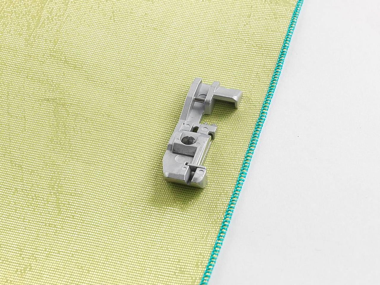 Yarn application foot on lime green fabric with blue overlocking - Husqvarna Viking