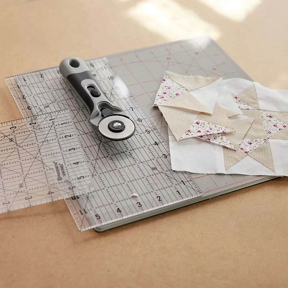 Quilting tools with fabric pieces on a measurement board.