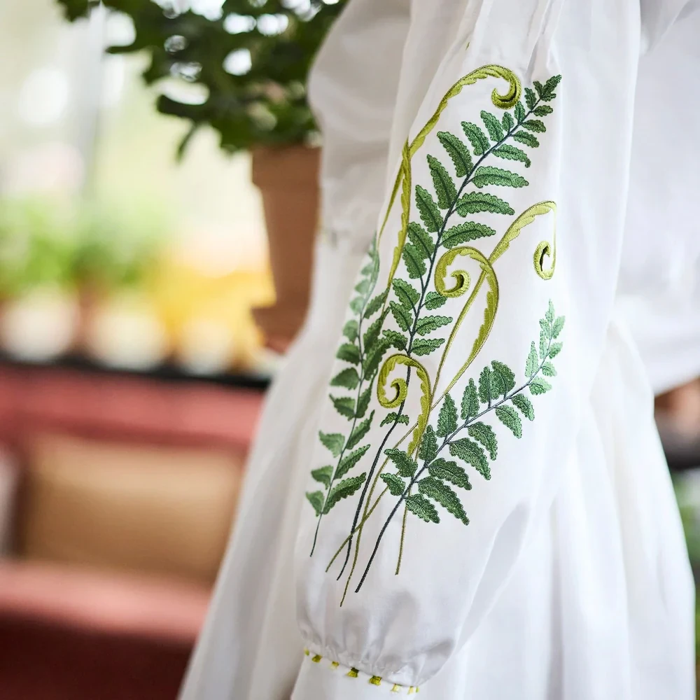 White garment sleeve with green and yellow fern embroidery - Husqvarna Viking design