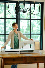Husqvarna Viking Epic 3 sewing machine in a cozy cottage setting, showcasing high-end features.