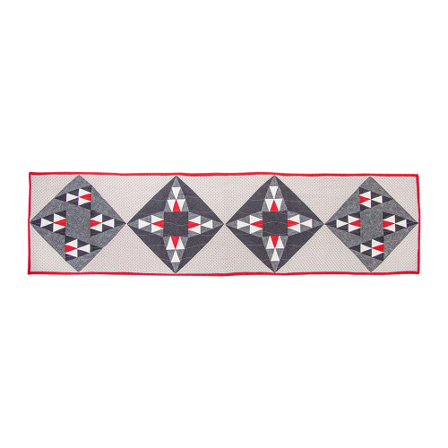 Intricate fabric pattern with geometric quilt designs in red and gray.