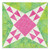 Colorful geometric fabric quilt in shades of pink, green, and white.