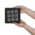 Hands holding a square black foam with nine grey felt squares arranged in a grid.