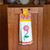 Colorful floral-patterned kitchen towel hanging on a wooden cabinet door.