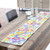 Colorful floral quilted table runner on a rustic wooden dining table.