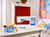 Modern sewing machine on a table surrounded by colorful fabric and decor.