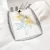 Sewing machine embroidering yellow and blue flowers on white fabric.