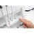Close-up of a sewing machine interface with a finger pressing a button.