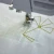 Sewing machine embroidery with green thread on patterned white fabric.