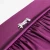 Sewing machine foot on purple gathered fabric.