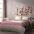 Colourful pastel striped quilt on bed with matching patchwork artwork - Husqvarna Viking creation