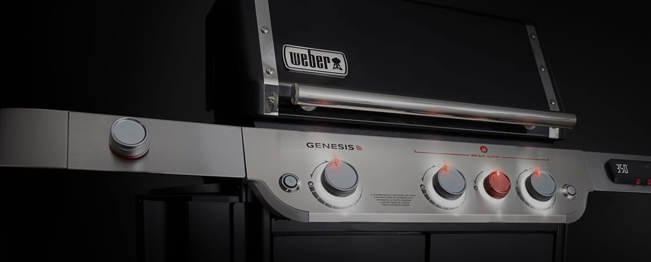 Weber Genesis gas grill at night with grill lights on, professionally assembled