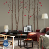 Brown birch tree wall decals with red birds creating a woodland accent behind a sofa in a modern living room