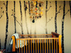 Dark gray and light gray birch tree wall decals installed behind a wood crib with woodland branch mobile