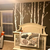 Birch tree wall decals installed in a woodland nursery with white tree decals on a dark wall behind a white crib