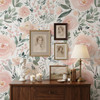 Olivia Rose Watercolor Wallpaper styled with vintage wood dresser, framed art, table lamp, candles, and oversized blush pink floral wall decor