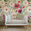 Jessica pink and red watercolor floral nursery wallpaper with a white crib, natural wood accents