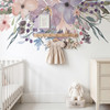 Pastel watercolor floral wall decal border above a nursery shelf and white crib with soft neutral baby room decor