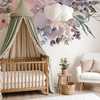 Pastel watercolor floral wall decal border above a canopy crib in a soft neutral nursery with blush and cream decor