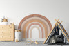 Neutral terracotta rainbow wall decal displayed in a playroom beside a wood dresser and black children’s tent