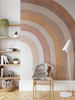 Right-half terracotta rainbow wall decal displayed in a reading corner with a wood chair, open shelving and floor lamp
