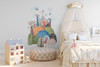 Medium fairytale mountain wall decal with pastel castle towers, hot air balloon and rainbow above a white nursery crib