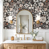 Skylar black floral wallpaper with oversized watercolor flowers in a bathroom with brass arched mirror, white vanity and warm wood accents