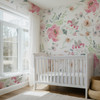 Large watercolor floral wallpaper surrounding a bright nursery with white crib