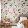 Emily Rose blush pink watercolor floral wallpaper in a warm neutral bedroom with a rattan chair