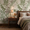 Oversized fern and meadow grass wallpaper in a masculine bedroom with dark wood furniture and neutral bedding