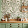 Green botanical wallpaper above sage kitchen cabinets with warm wood countertops shown in the 26-inch scale