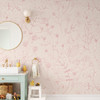Pink wildflower floral wallpaper with delicate blush floral linework on a warm beige background for nursery bedroom bathroom and romantic cottage interiors