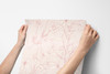Pink wildflower floral wallpaper with delicate blush floral linework on a warm beige background for nursery bedroom bathroom and romantic cottage interiors
