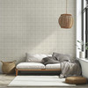 Neutral plaid wallpaper in 13 inch repeat with soft beige linen pattern behind white sofa and woven pendant light